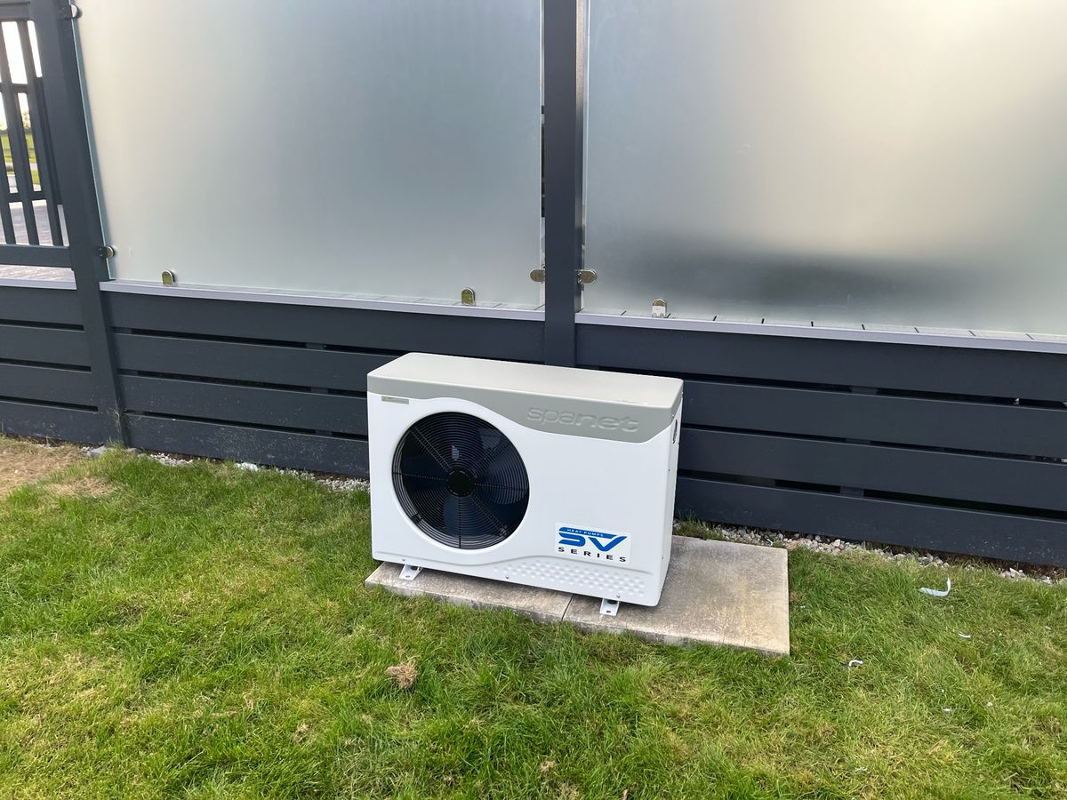 Heat pump set against frosted privacy panels — compact outdoor install by RL Spa