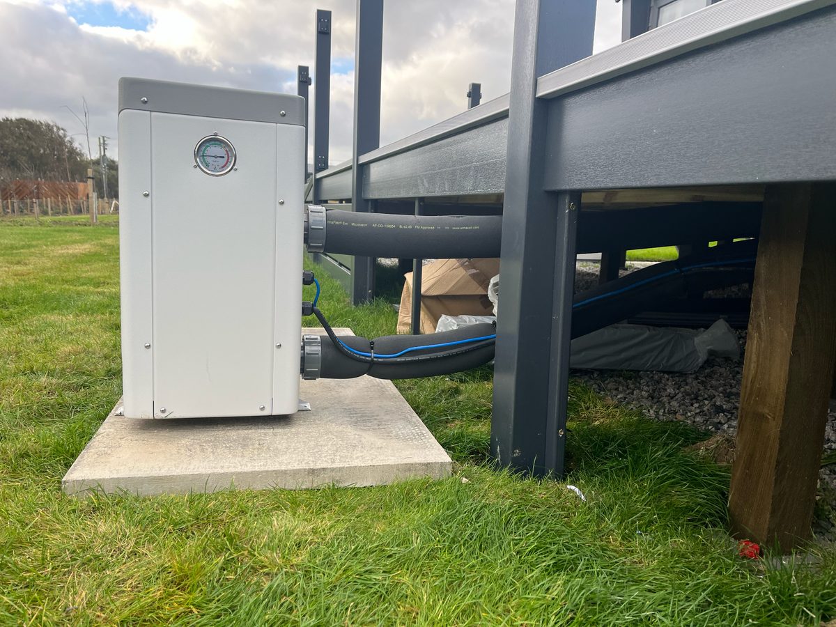 Under-deck plumbing with insulated lines and tidy concrete base